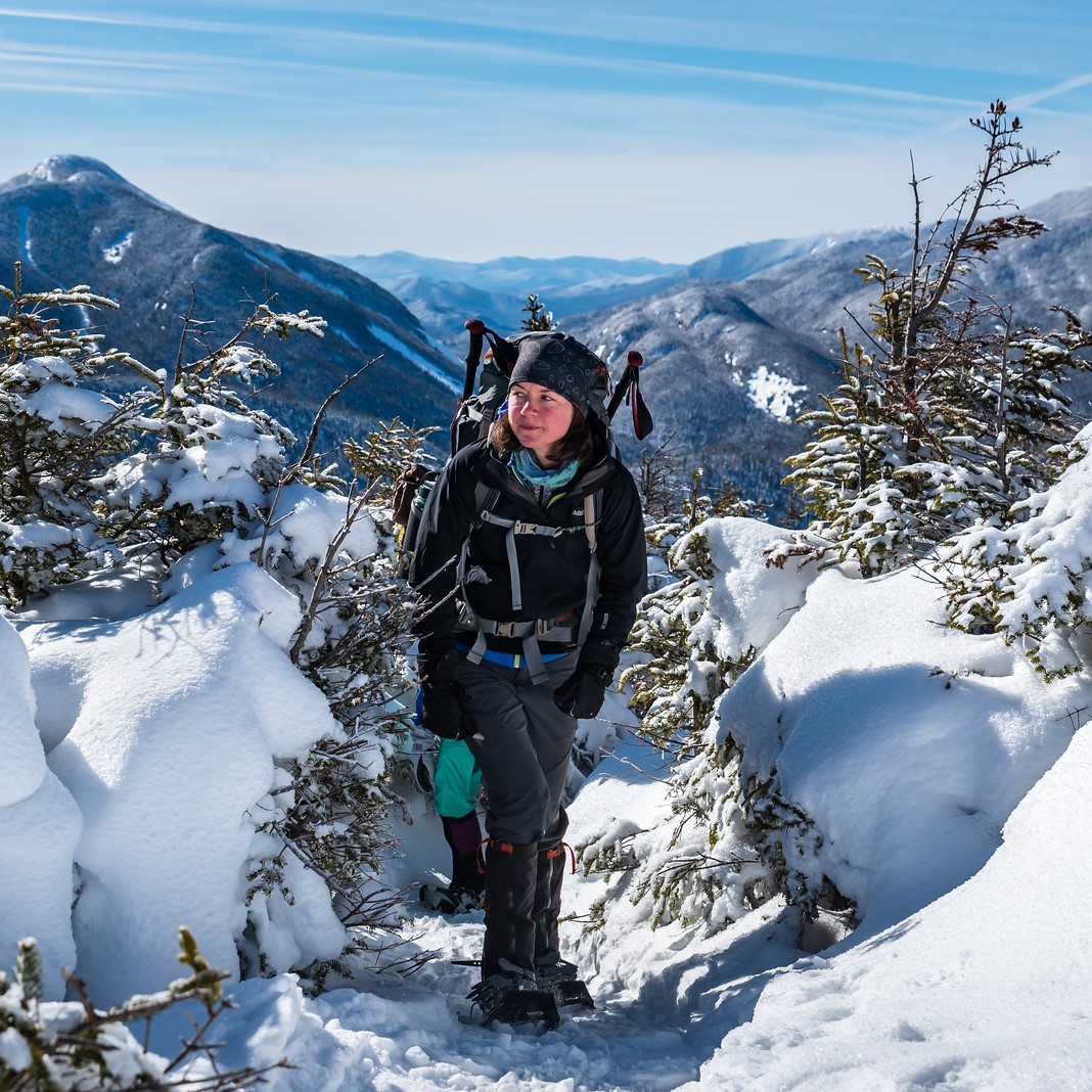 woman hiking a mountain in the snow